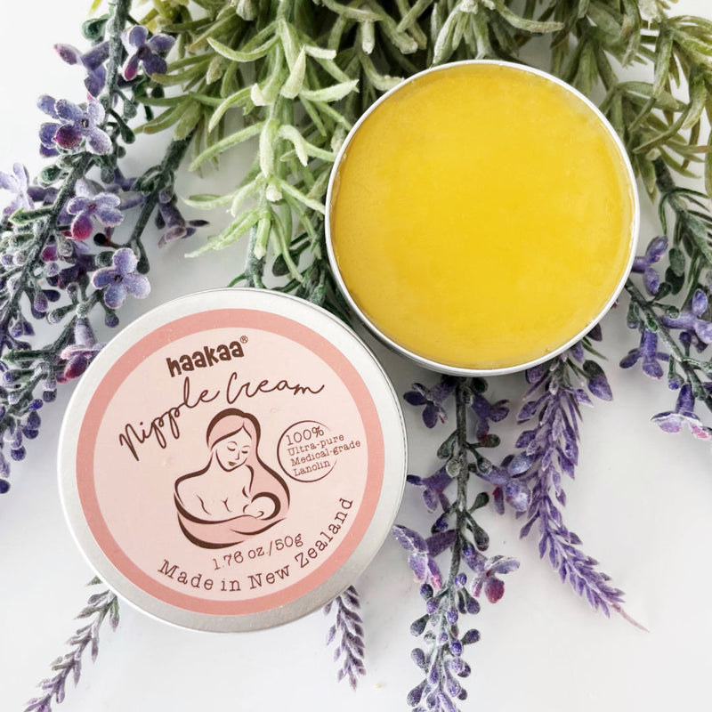 An open tin of Haakaa Nipple Cream on a bed of lavender